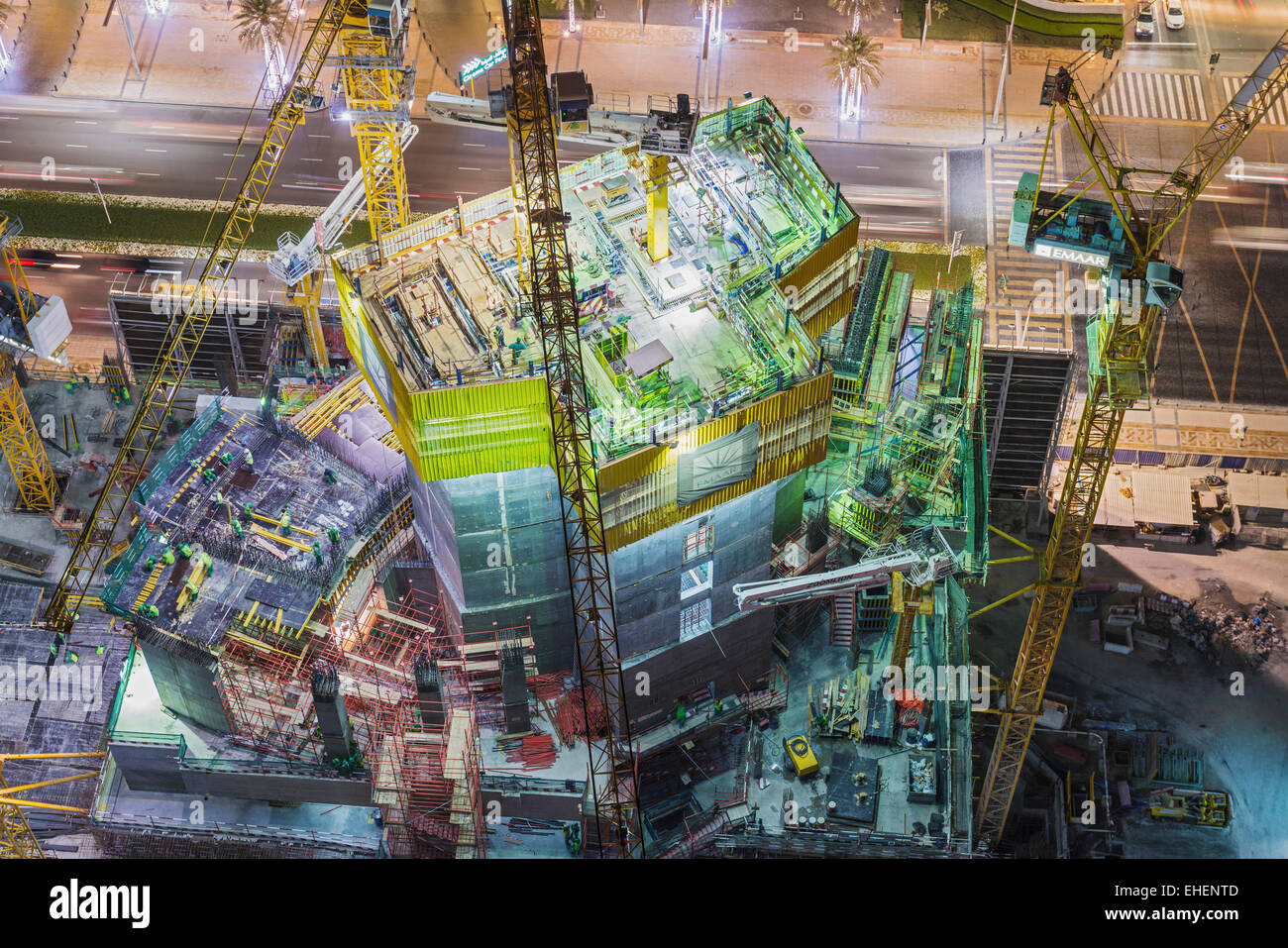Sito in costruzione di appartamento torre grattacielo sotto i proiettori di notte in Dubai Emirati Arabi Uniti Foto Stock