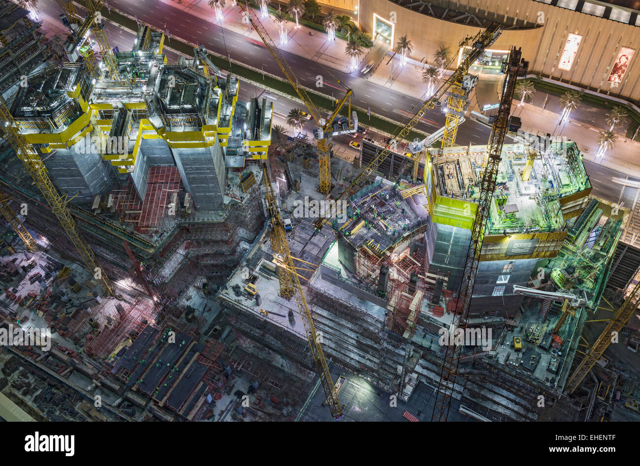 Sito in costruzione di appartamento torri grattacielo sotto i proiettori di notte in Dubai Emirati Arabi Uniti Foto Stock