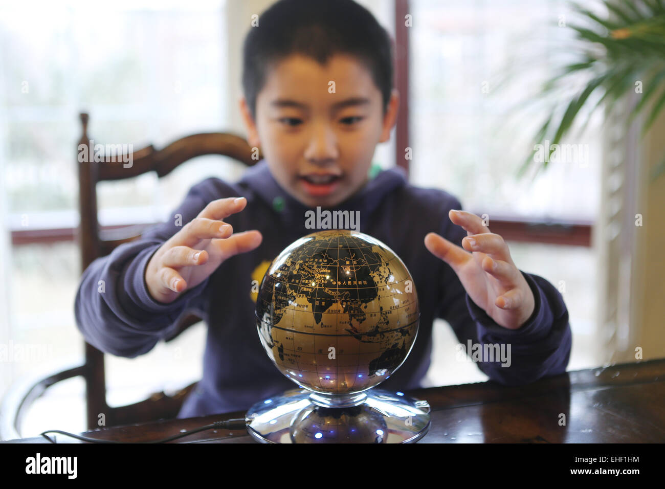 Il ragazzo stese la mano per trattenere un globo Foto Stock