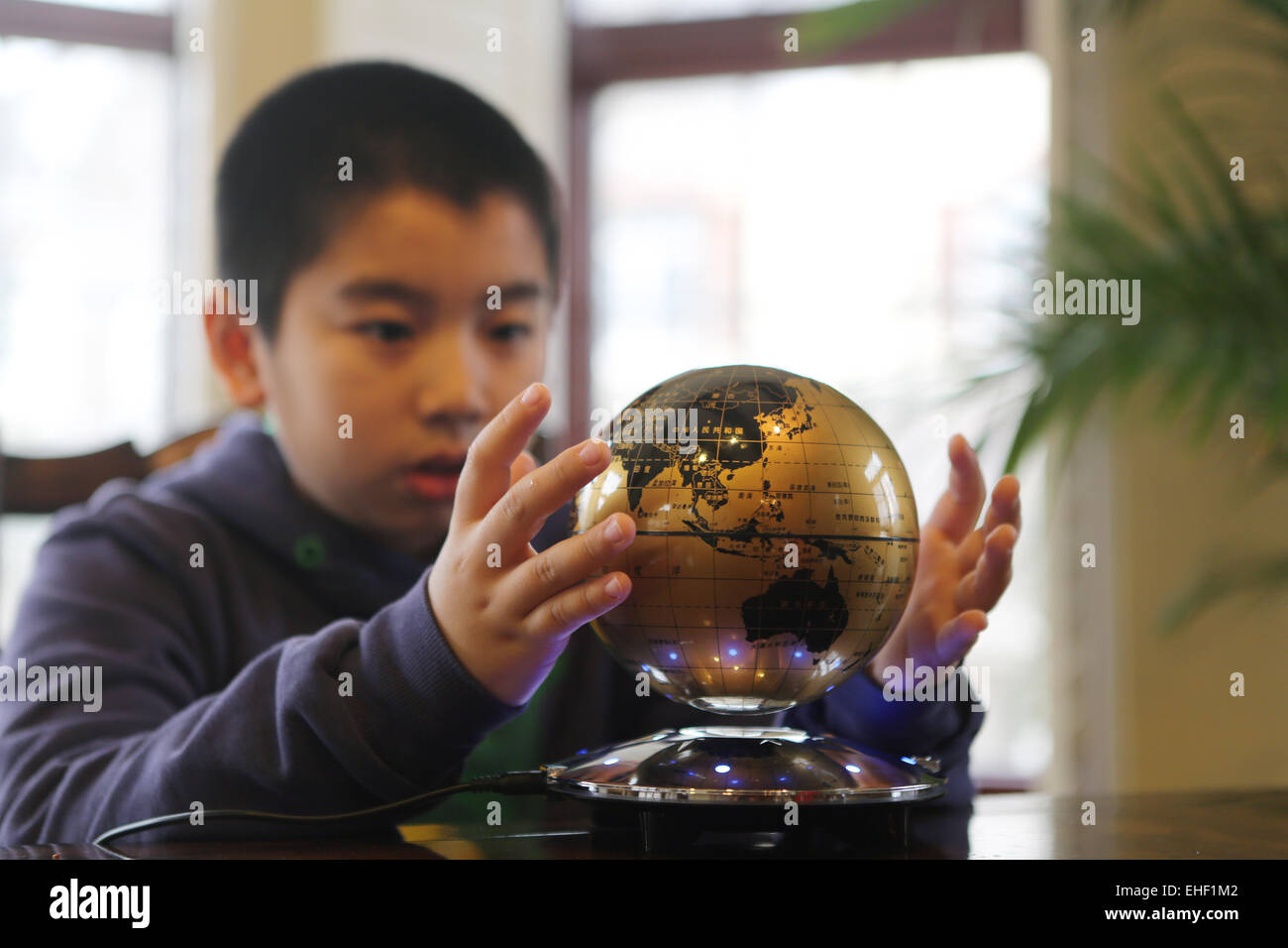 Il ragazzo stese la mano per trattenere un globo Foto Stock