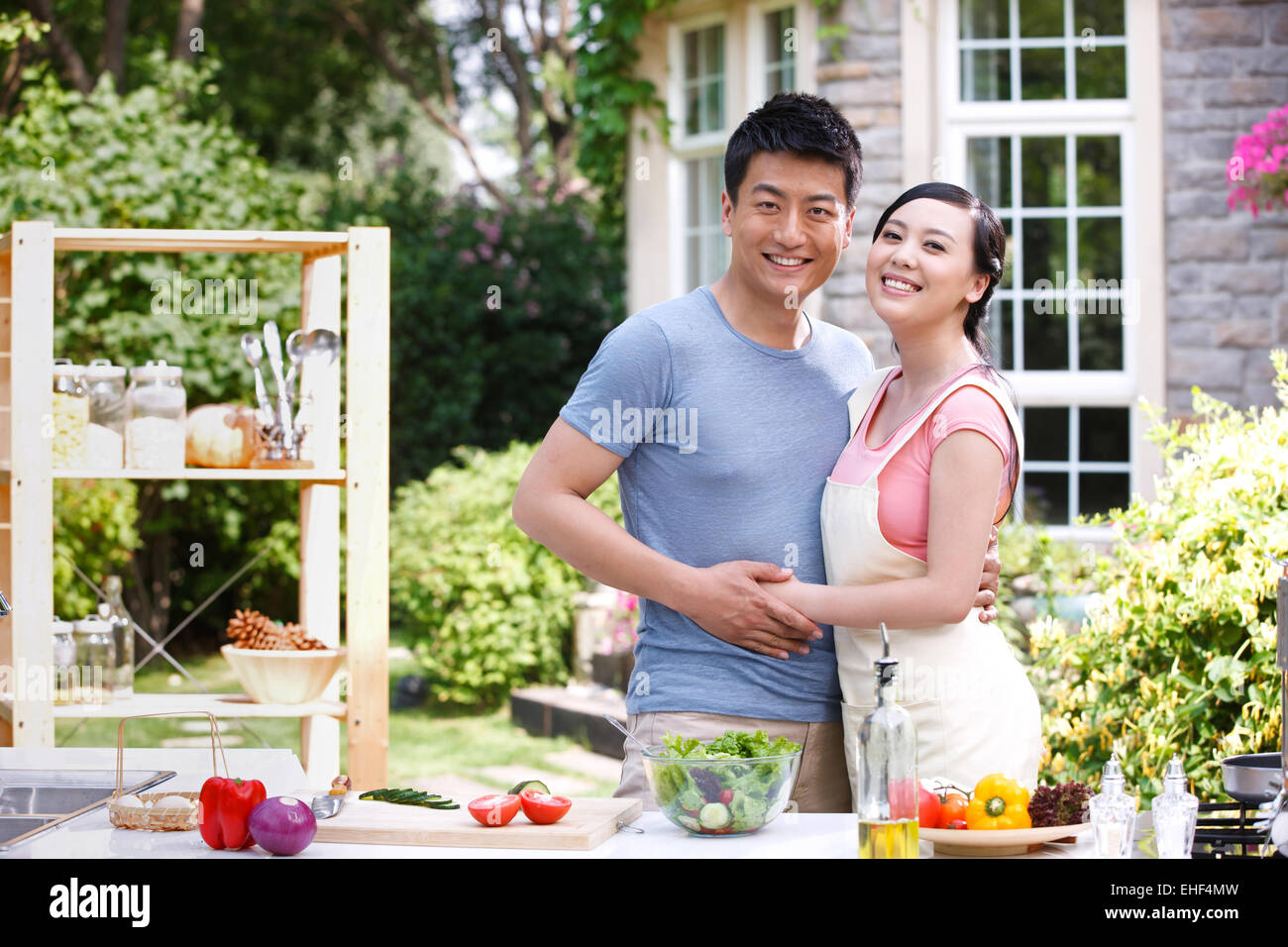 Abbracciando la giovane coppia nella cucina esterna Foto Stock