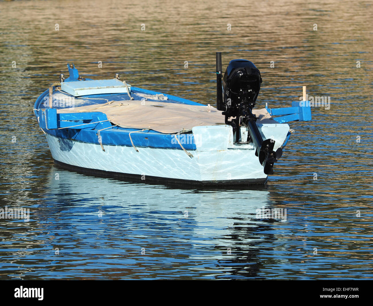 Piccole chiatte in legno barca con motore fuoribordo galleggia attraverso la laguna blu delle onde Foto Stock