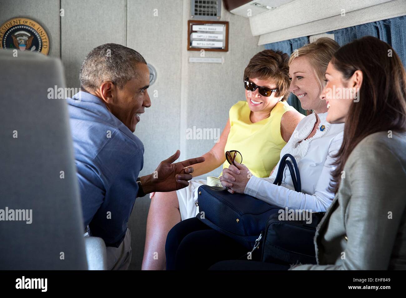 Il Presidente Usa Barack Obama parla con, da sinistra, Senior Advisor Valerie Jarrett, Anita Breckenridge, Vice Capo del personale per le operazioni e il vice segretario stampa Jennifer Friedman a bordo di una marina durante il volo dalla casa bianca a base comune Andrews per un viaggio a Milwaukee, Wisconsin sul lavoro giorno sett. 1, 2014. Foto Stock