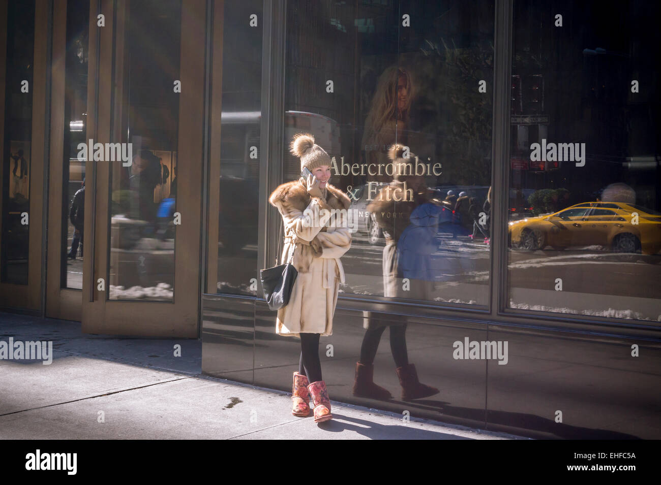 Un acquirente sul suo telefono cellulare al di fuori di Abercrombie & Fitch store sulla Fifth Avenue a New York venerdì 6 marzo 2015. Il rivenditore ha postato un 14 percento di calo delle vendite nel trimestre festivo e avvertito di tempi duri come la marca si riposiziona. (© Richard B. Levine) Foto Stock