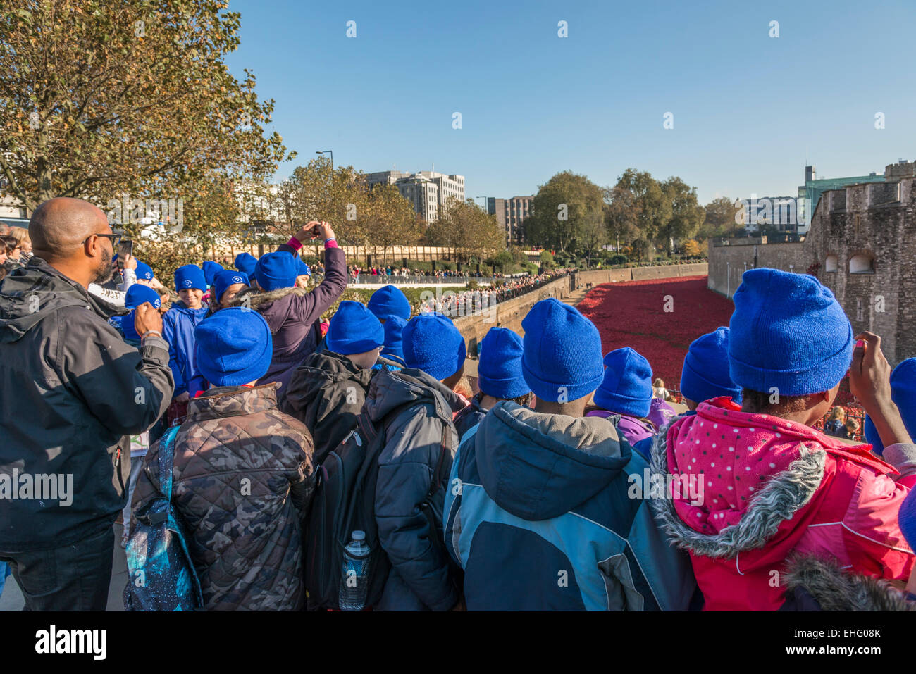 Un gruppo di bambini della scuola di visitare la Torre di Londra per visualizzare la ceramica di papavero rosso per visualizzare il giorno dell'armistizio - solo uso editoriale Foto Stock