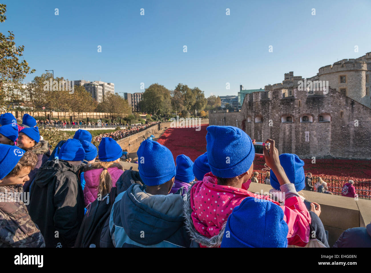 Un gruppo di bambini della scuola di visitare la Torre di Londra per visualizzare la ceramica di papavero rosso per visualizzare il giorno dell'armistizio - solo uso editoriale Foto Stock