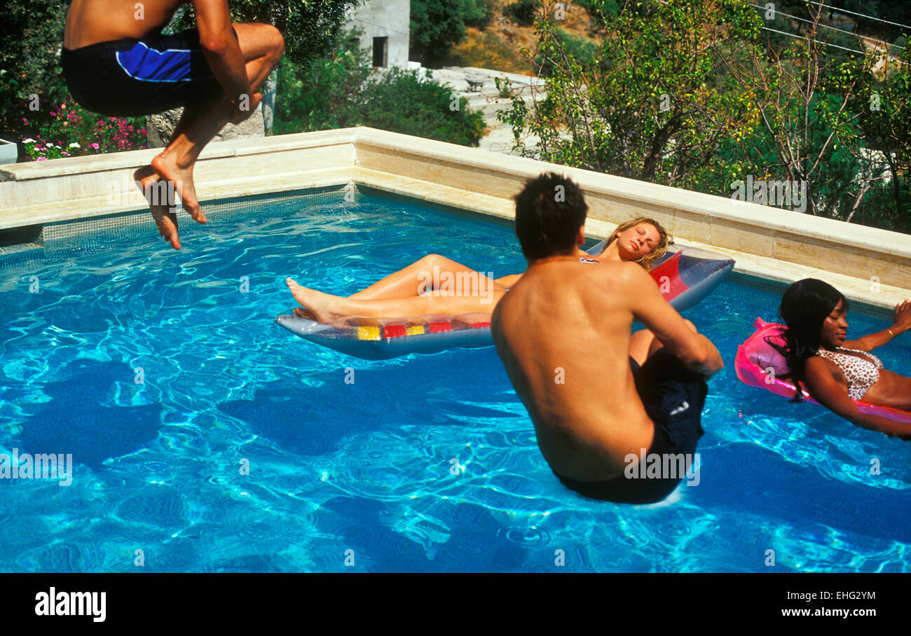 Ragazzi bombardamenti di immersione in una piscina in una villa a Ibiza. Foto Stock