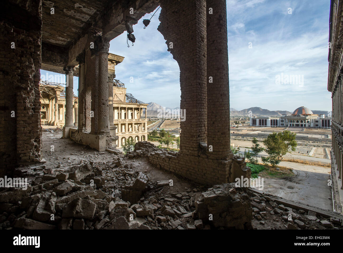 Ha rovinato il corridoio della Darul Aman Palace durante il Mujahideen fazioni hanno combattuto per il controllo di Kabul all'inizio degli anni novanta e la costruzione del nuovo parlamento sullo sfondo, Kabul, Afghanistan Foto Stock