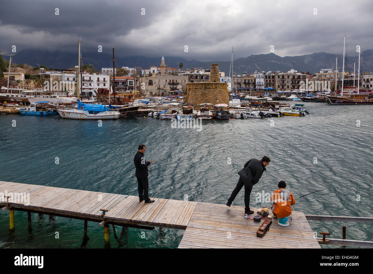 Gli uomini la pesca nel porto di Girne (Kyrenia), la parte settentrionale di Cipro Foto Stock