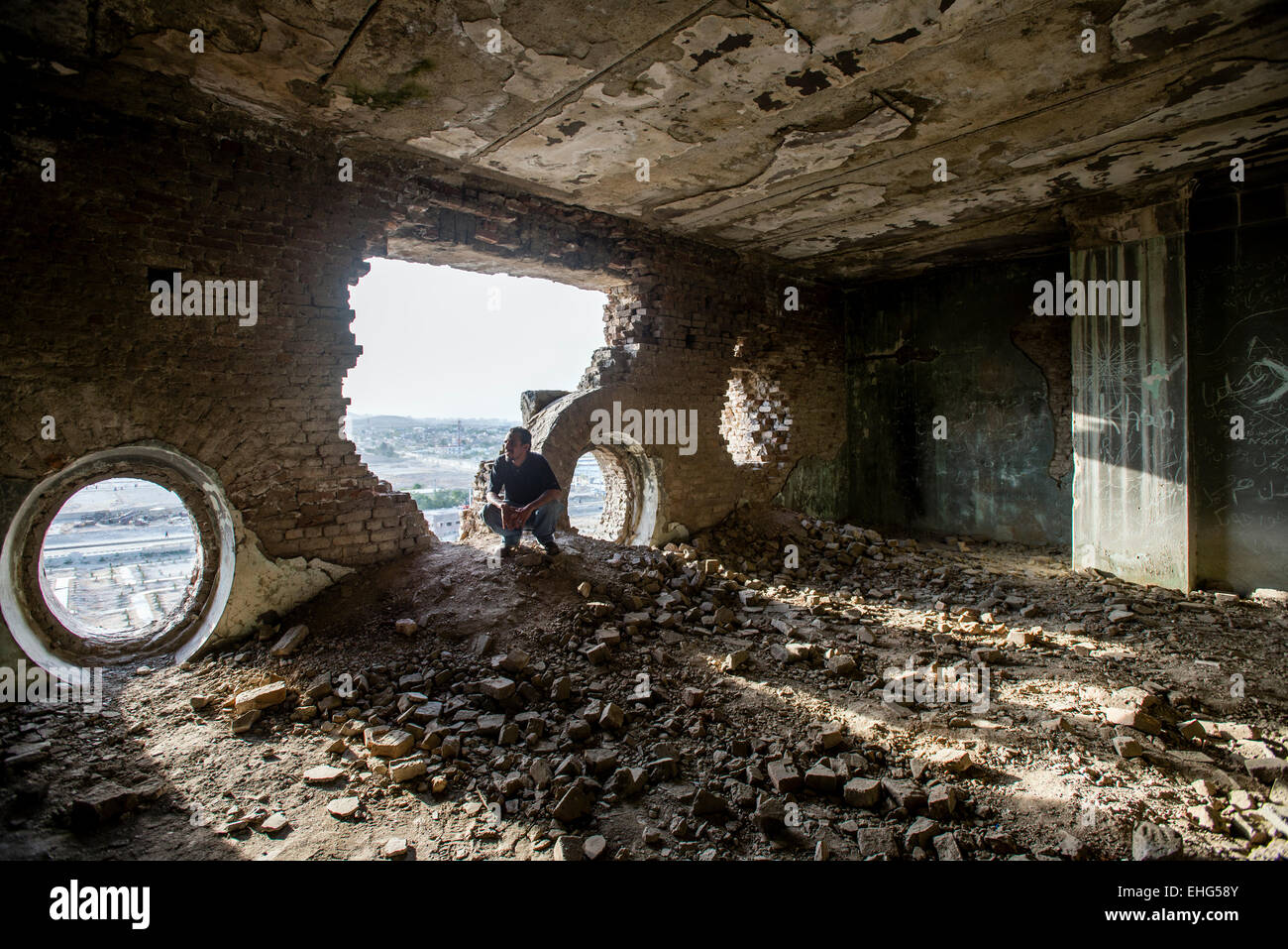 Tossicodipendente uomo afgano in posa nella hall del rovinato Darul Aman Palace a Kabul, Afghanistan Foto Stock