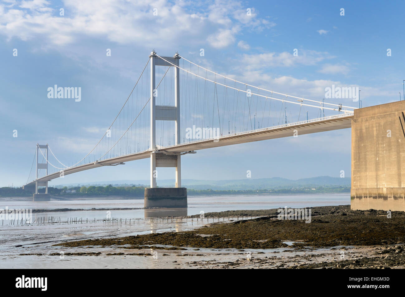 Il vecchio Severn suspension bridge spanning Severn Estuary a bassa marea in una giornata di sole Foto Stock