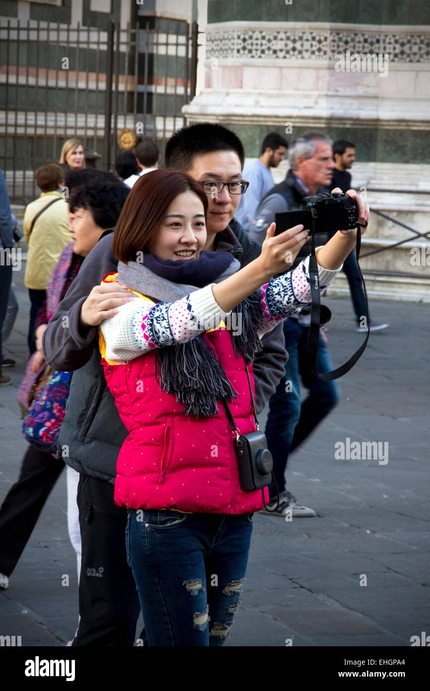 I turisti tenendo 'selfie' foto davanti al Duomo e il campanile, la Piazza del Duomo di Firenze, Toscana, Italia Foto Stock
