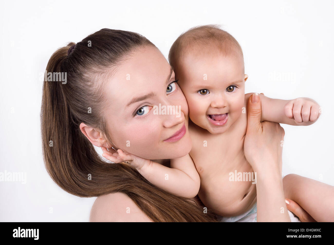 Una giovane donna caucasica tenendo una bambina o ragazzo e sorridente. Ritratto isolato. Foto Stock