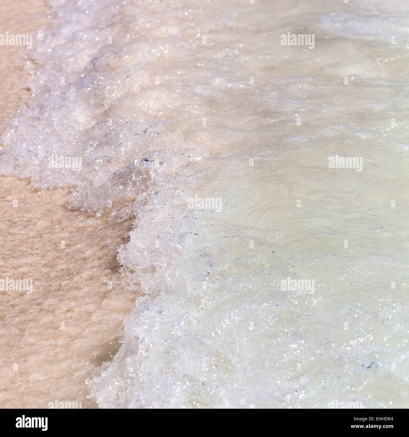 Le onde del mare con la schiuma sulla spiaggia di sabbia bianca. Free sfondo copyspace Foto Stock