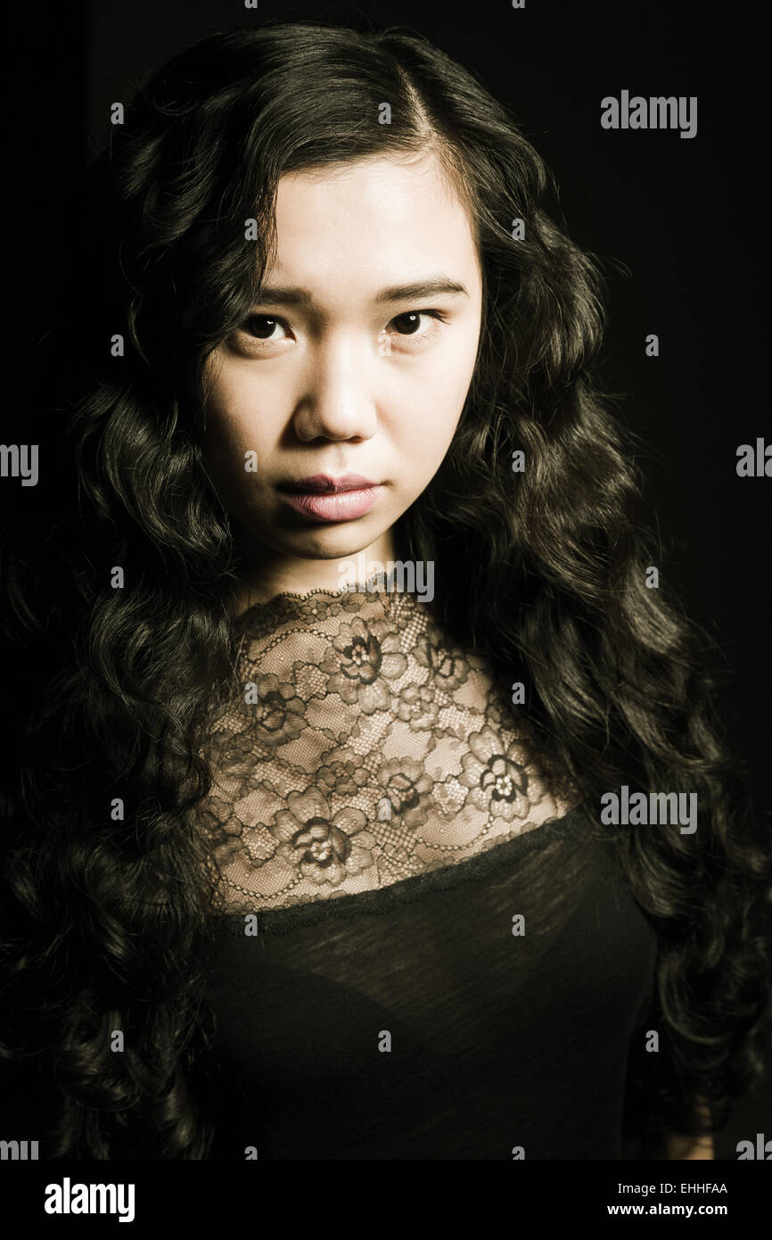 Ritratto del bellissimo modello di moda con i capelli lunghi che posano su sfondo nero. Foto Stock