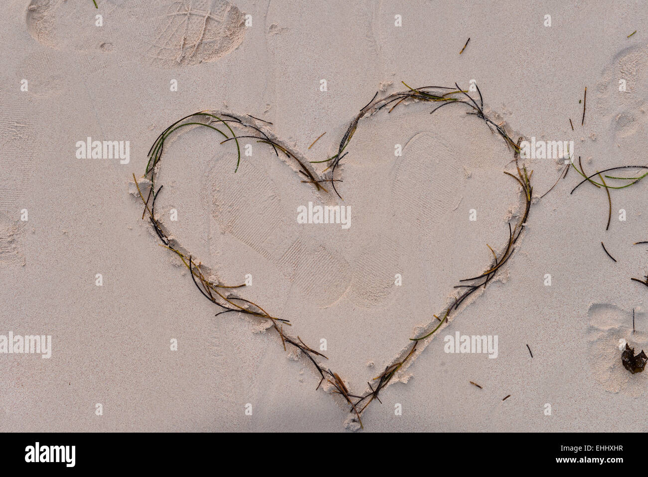 Cuore trafitto da Cupido freccia del tracciato nella sabbia Foto Stock