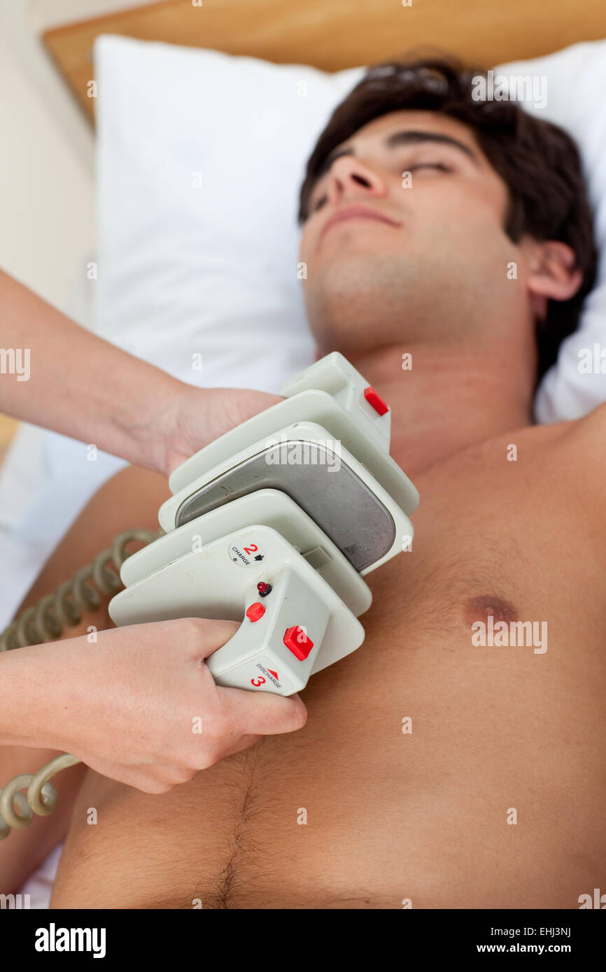 Scena di emergenza: medico utilizzando un defibrillatore Foto Stock
