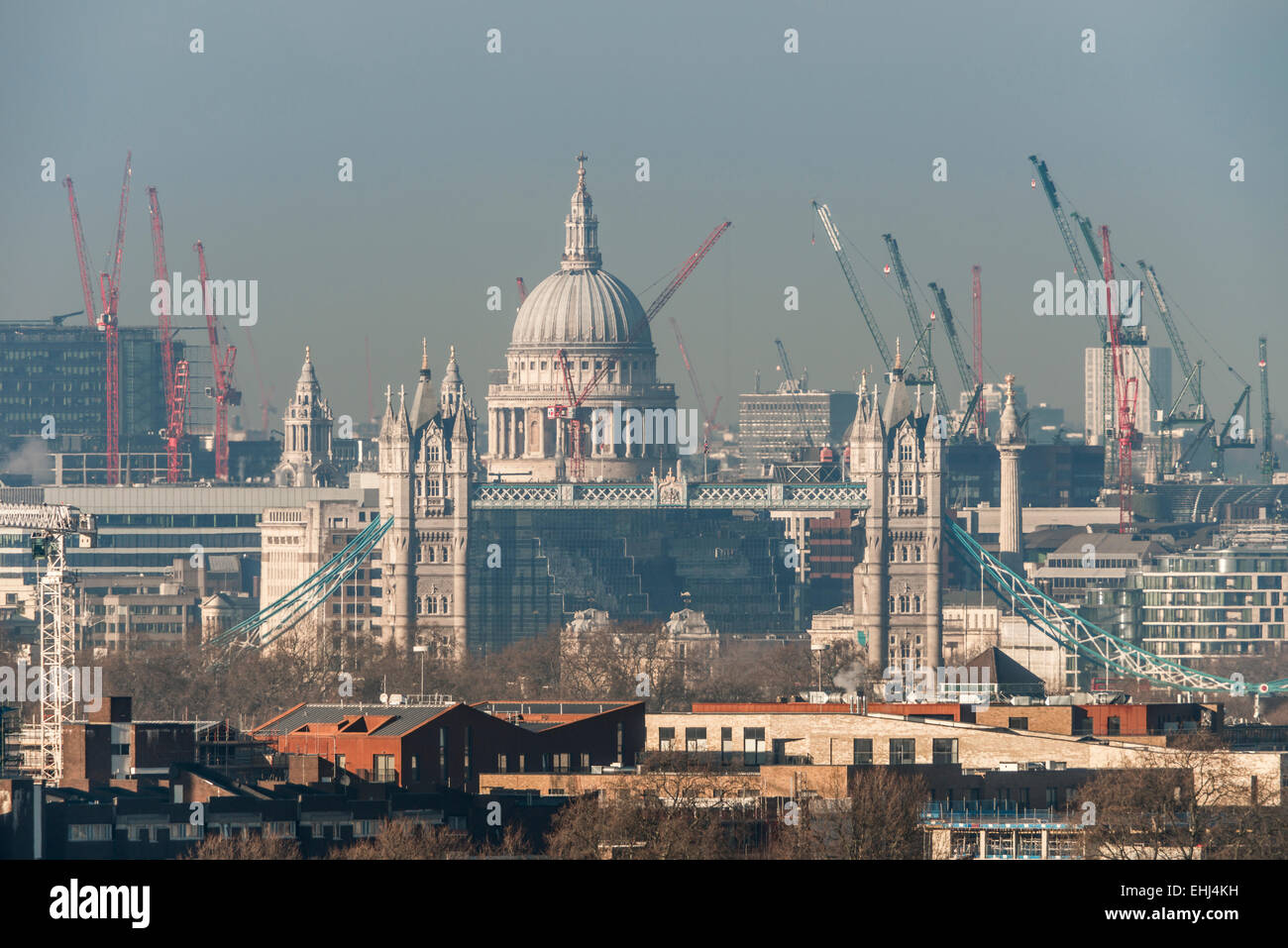 La cupola della cattedrale di St Paul visto sopra il Tower Bridge insieme con la gru nel cielo che mostra la costruzione in Londra Foto Stock