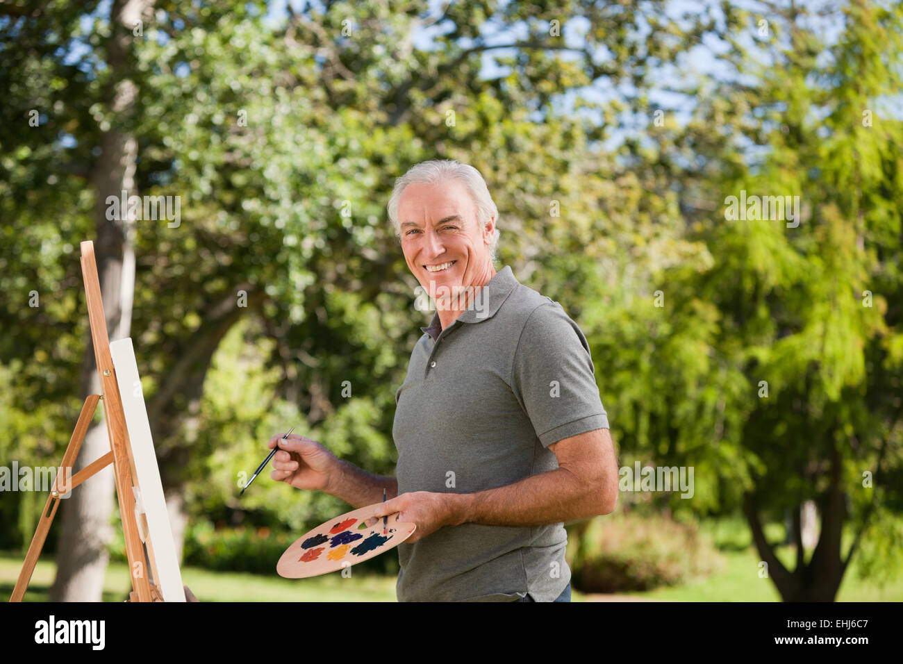 Uomo maturo pittura in giardino Foto Stock