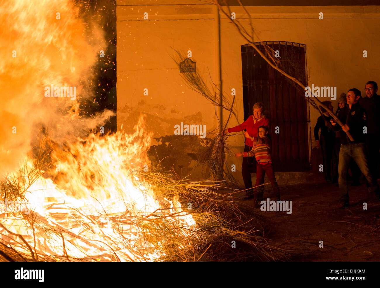 Gli abitanti di un villaggio di gettare benzina sul fuoco nel villaggio di Torviscon durante il fuoco Torviscon Festival in Andalusia, sud della Spagna Foto Stock