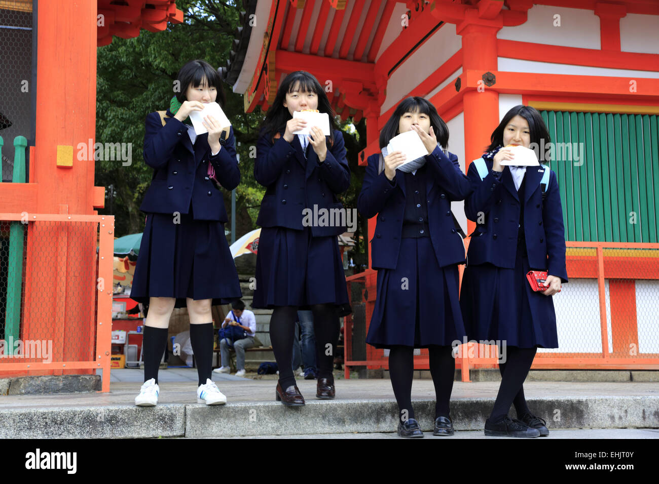 Le ragazze della scuola avente il pranzo presso la porta del Santuario Yaska-Jinjia durante una gita, Gion, Kyoto in Giappone Foto Stock