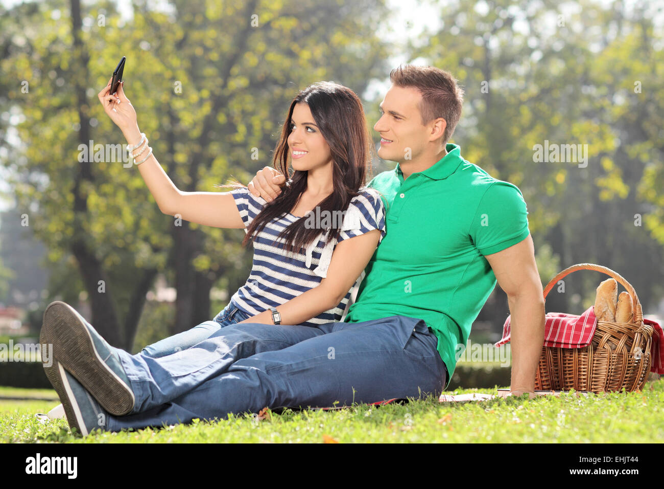 Ragazza tenendo un selfie con il suo ragazzo in un parco Foto Stock