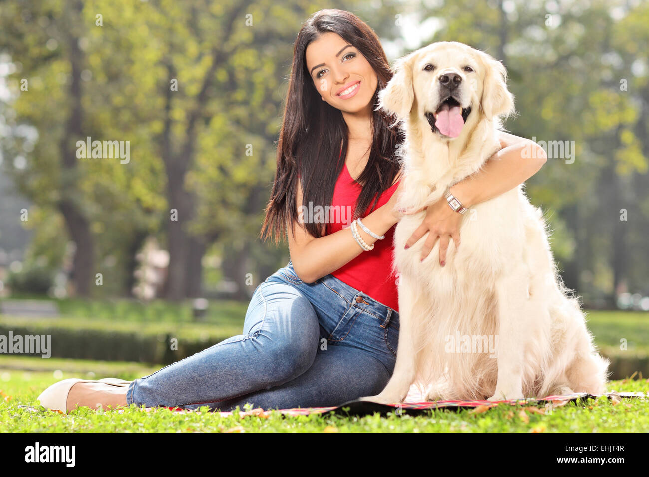 Giovane ragazza in posa con il suo cane in un parco Foto Stock