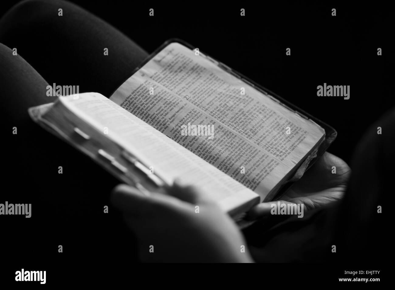 Un close-up di un cristiano donna seduta e la lettura della Bibbia. Molto leggera profondità di campo. Foto Stock