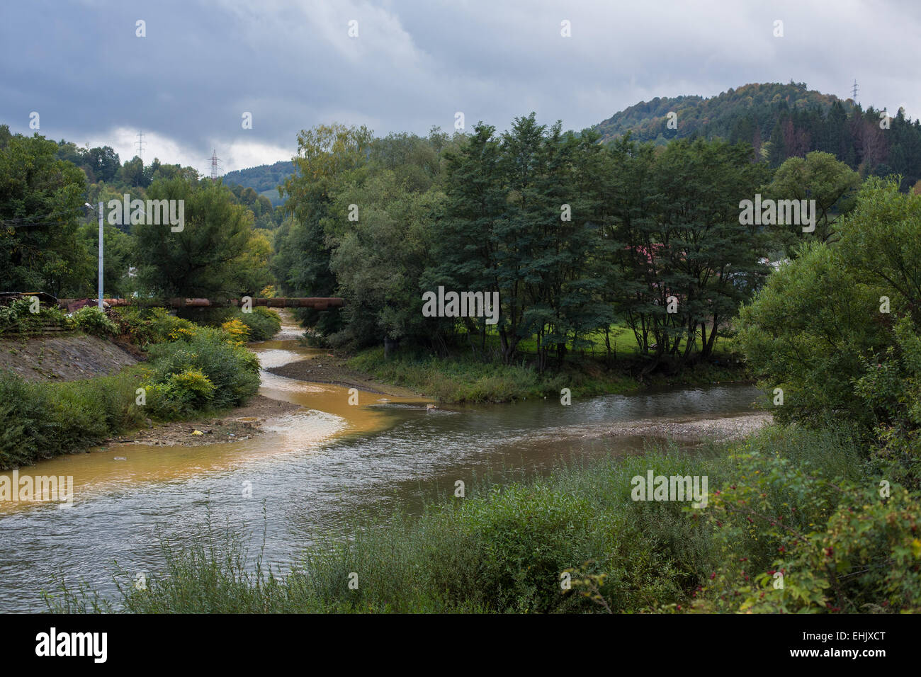 Abrud e Ariete creek si incontrano a Virs in Transilvania Romania. Acqua inquinata di Abrud creek proviene da Rosia Montana di miniera Foto Stock