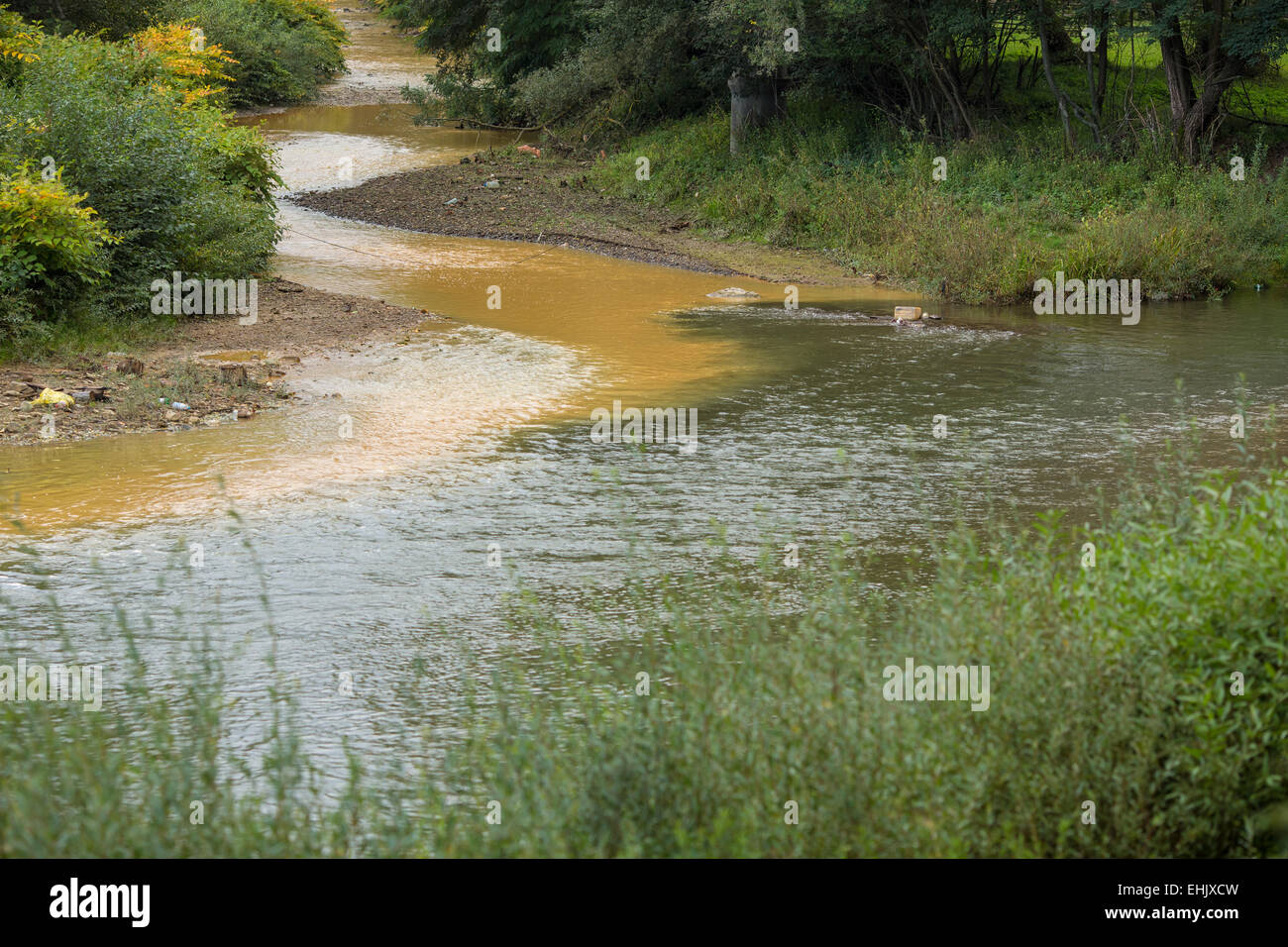 Abrud e Ariete creek si incontrano a Virs in Transilvania Romania. Acqua inquinata di Abrud creek proviene da Rosia Montana di miniera Foto Stock