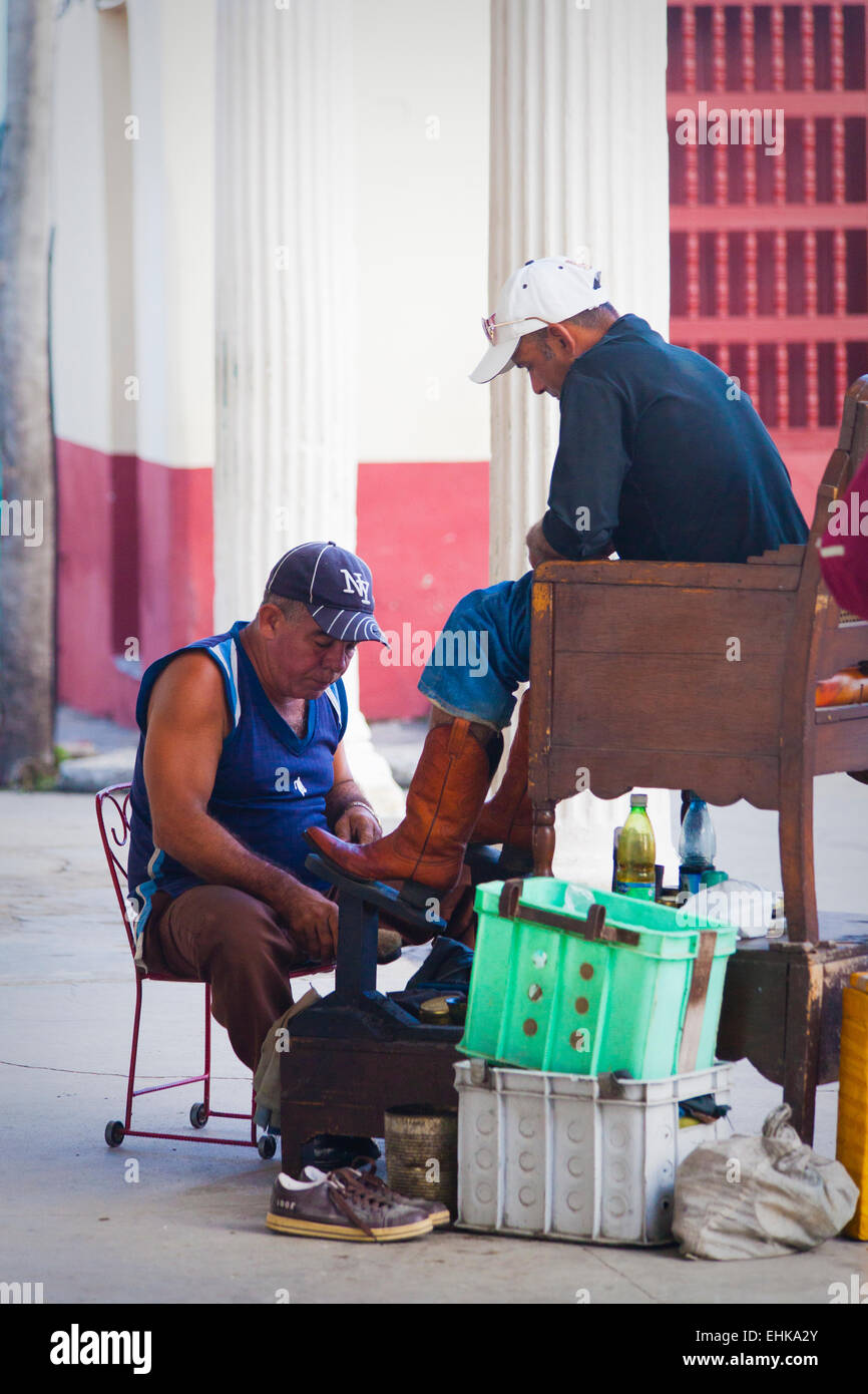 Un uomo risplende di scarpe in Sancti Spiritus, Cuba Foto Stock