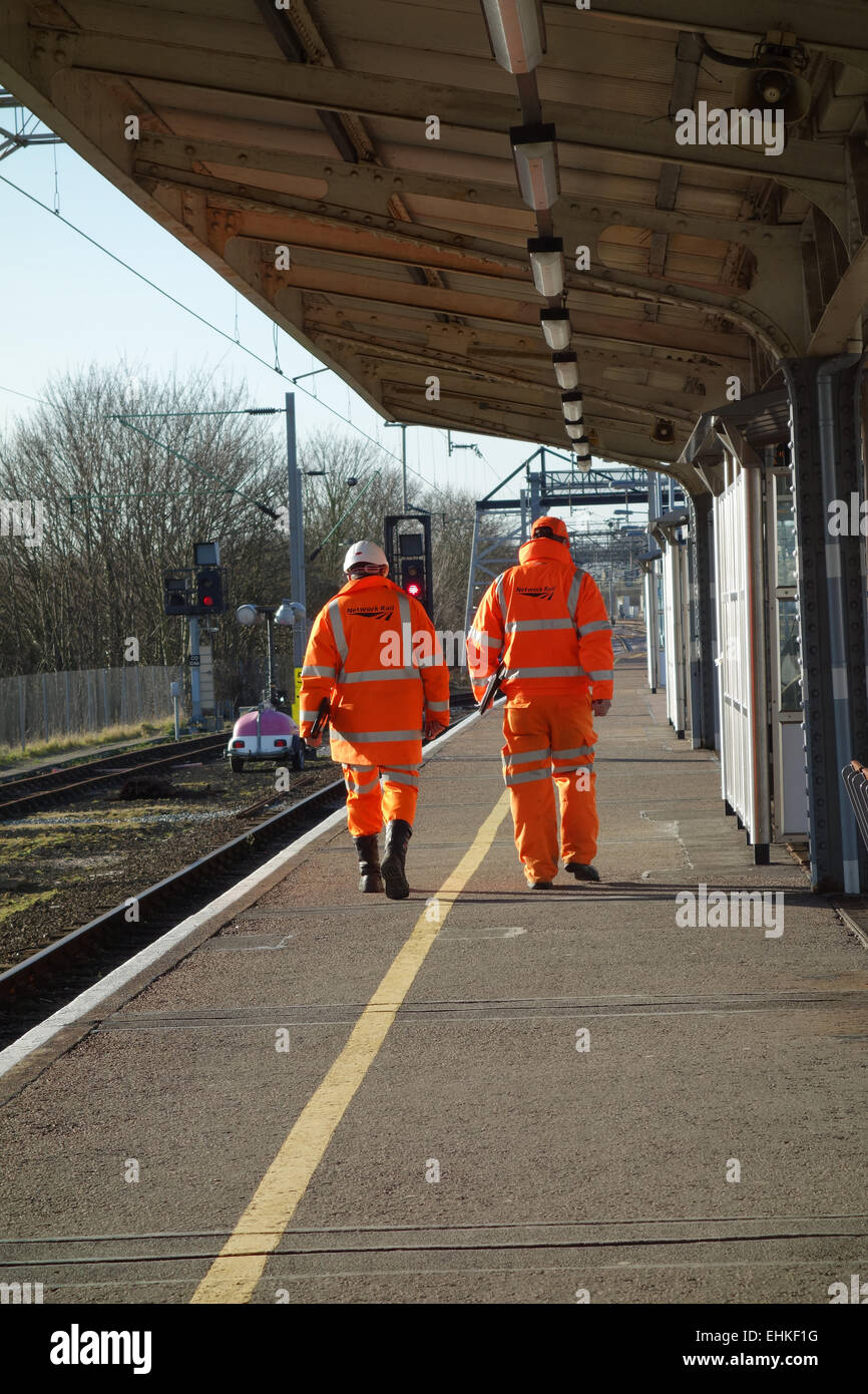 La guida della rete dei lavoratori a piedi lungo la piattaforma di Colchester Stazione Nord, Essex Foto Stock