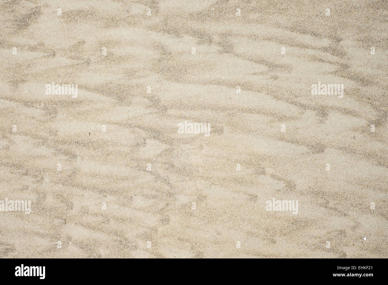 Texture di sabbia sulla spiaggia, con disegni realizzati dal mare. Foto Stock