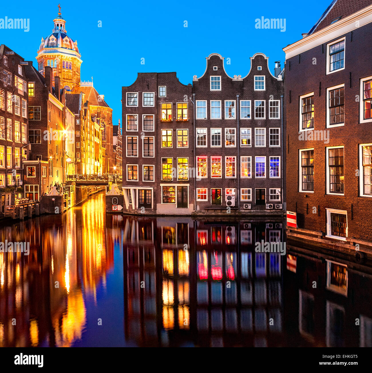 I canali di Amsterdam di notte vicino al quartiere a luci rosse. Basilica di San Nicolaaskerk di San Nicola, Zeedijk e il canale di Oudezijds Kolk Foto Stock