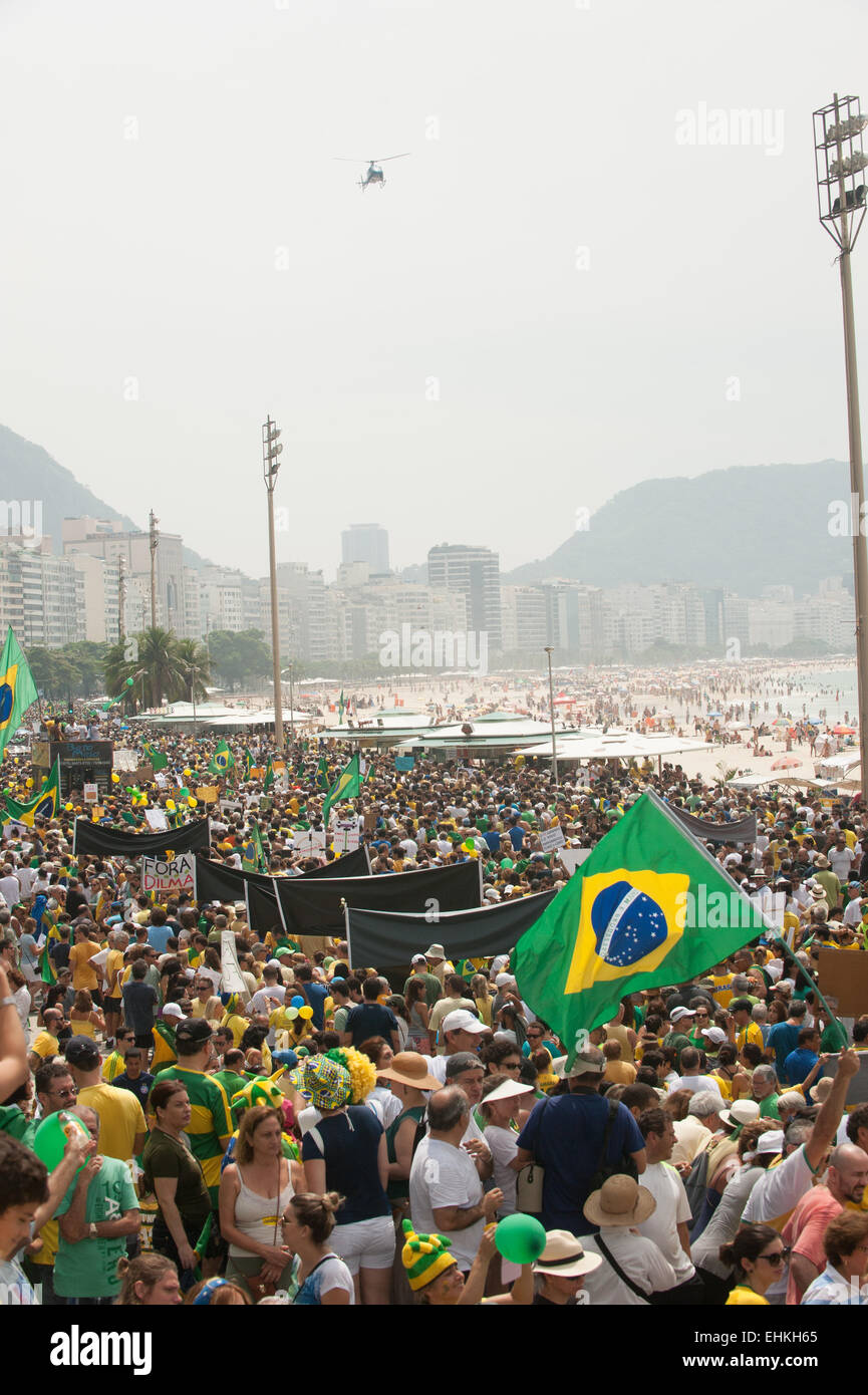 Manifestanti marzo sulla spiaggia di Copacabana mentre una Polizia Militare Elicottero vola overhead. Rio de Janeiro, Brasile, 15 marzo 2015. Dimostrazioni popolari contro il Presidente Dilma Rousseff in Copacabana. Foto © Sue Cunningham sue@scphotographic.com. Foto Stock