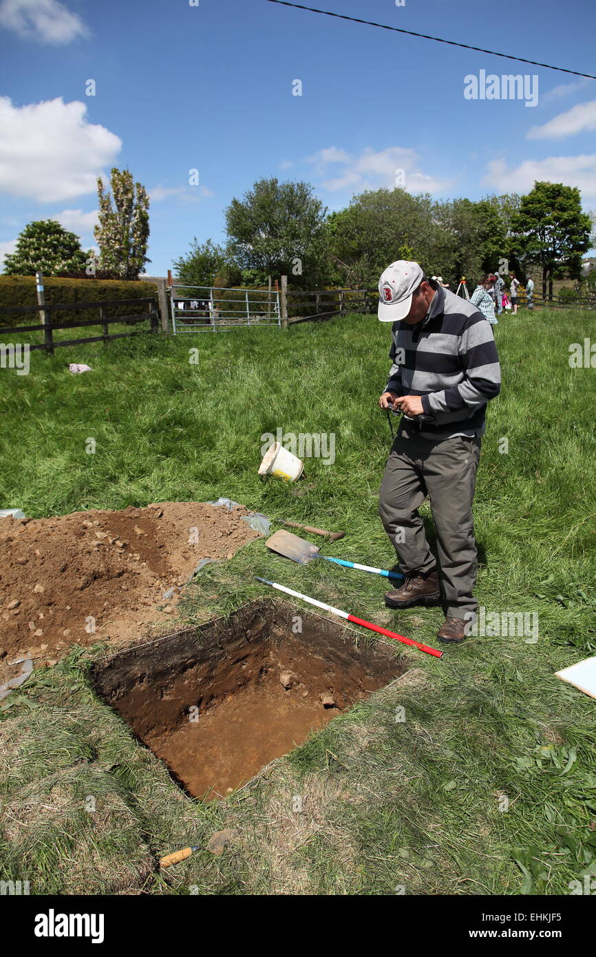 L archeologo, Norman Redhead, prende alcune immagini per registrare un test buca scavata in corrispondenza del sito di Castleshaw Roman Fort Saddleworth Foto Stock