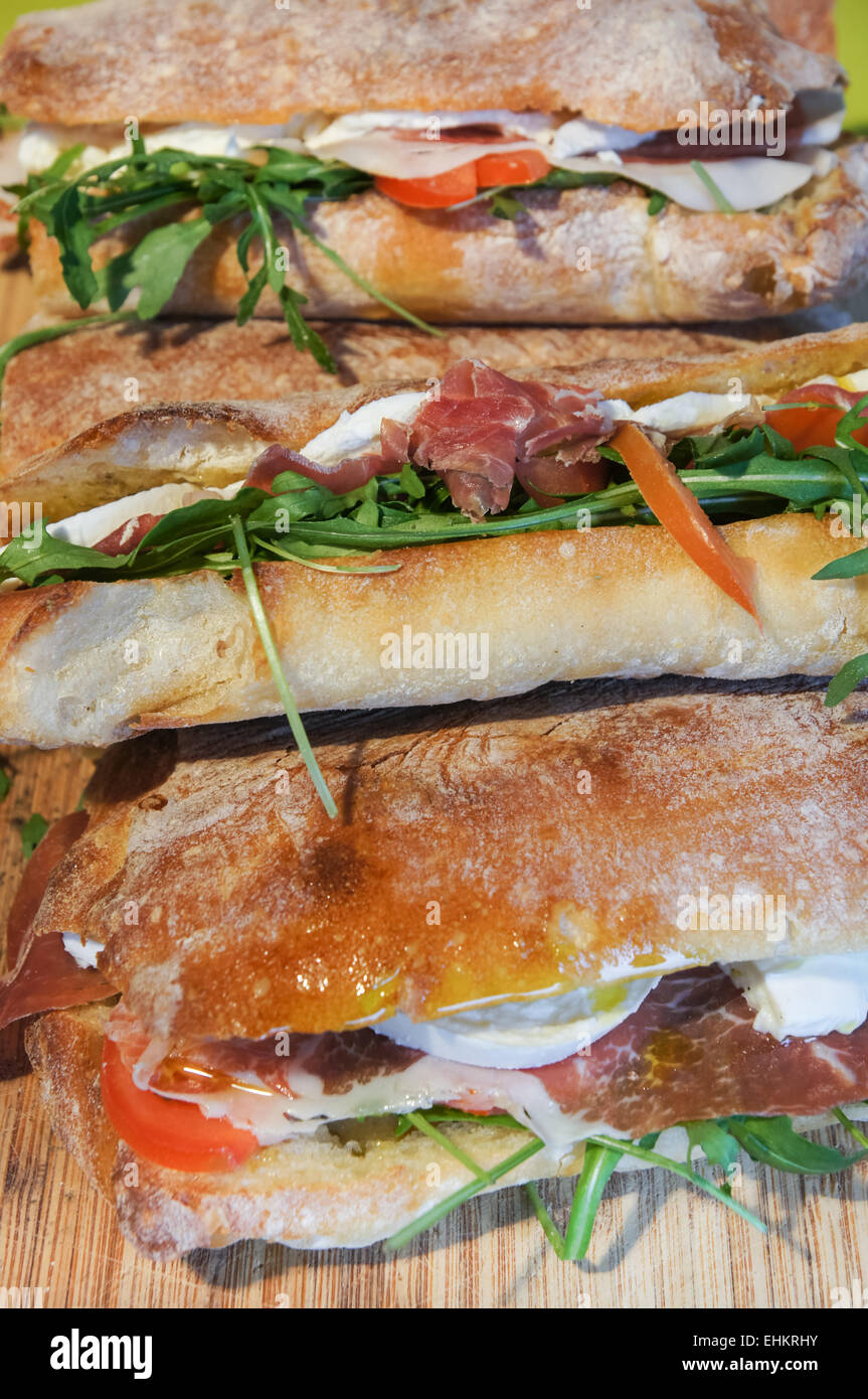 La ciabatta in sandwich con Wild Rocket, il prosciutto crudo, pomodoro e mozzarella Foto Stock