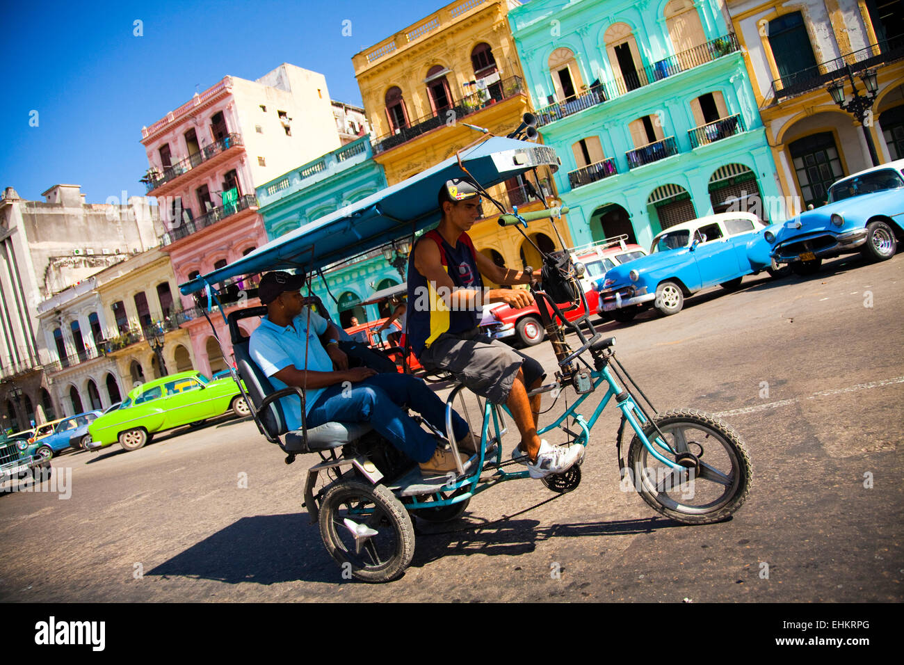 Auto classiche e taxi bicicletta sul Paseo de Marti, Havana, Cuba Foto Stock