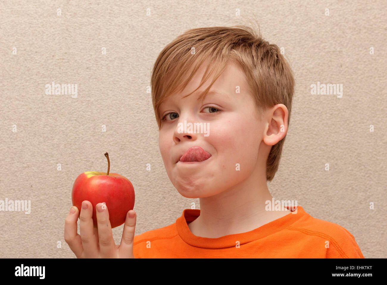 Ragazzo con apple leccare la sua lingua Foto Stock