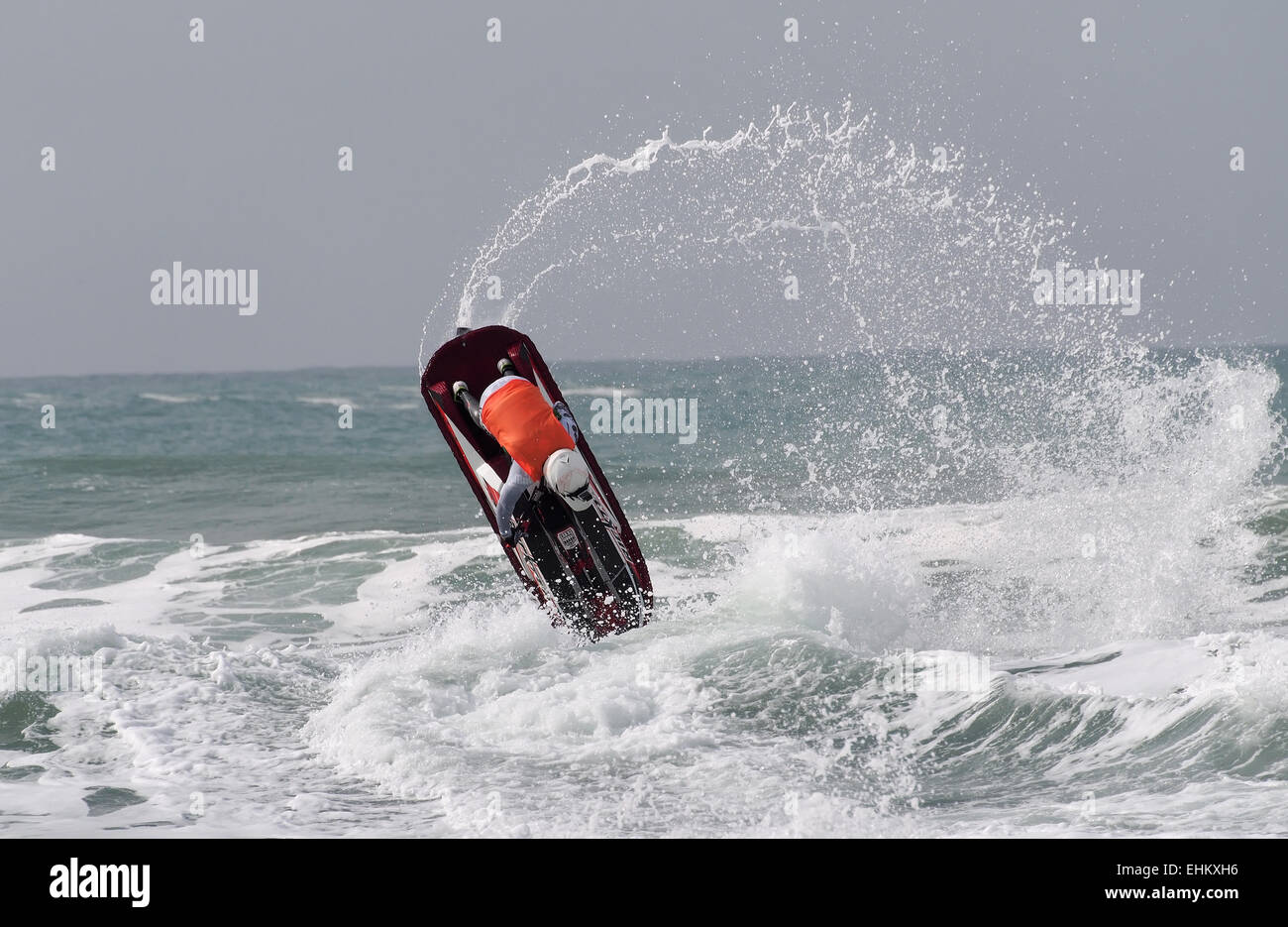 Maschio di jet ski concorrente esegue l'azione dell'antenna si sposta nella rottura grande surf su Newquay Fistral Beach Foto Stock