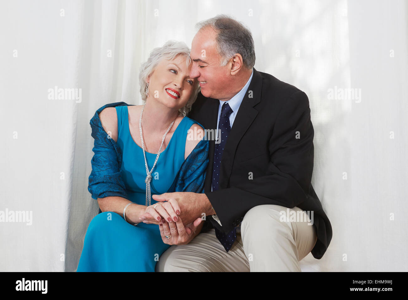 Sorridente coppia di anziani in formale abbracci di usura Foto Stock