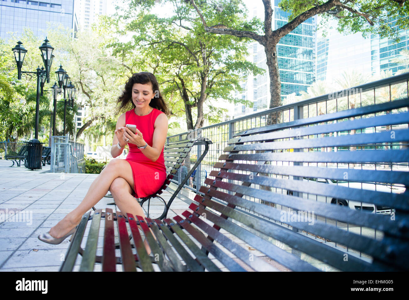 Imprenditrice caucasica utilizzando il cellulare in parco urbano Foto Stock