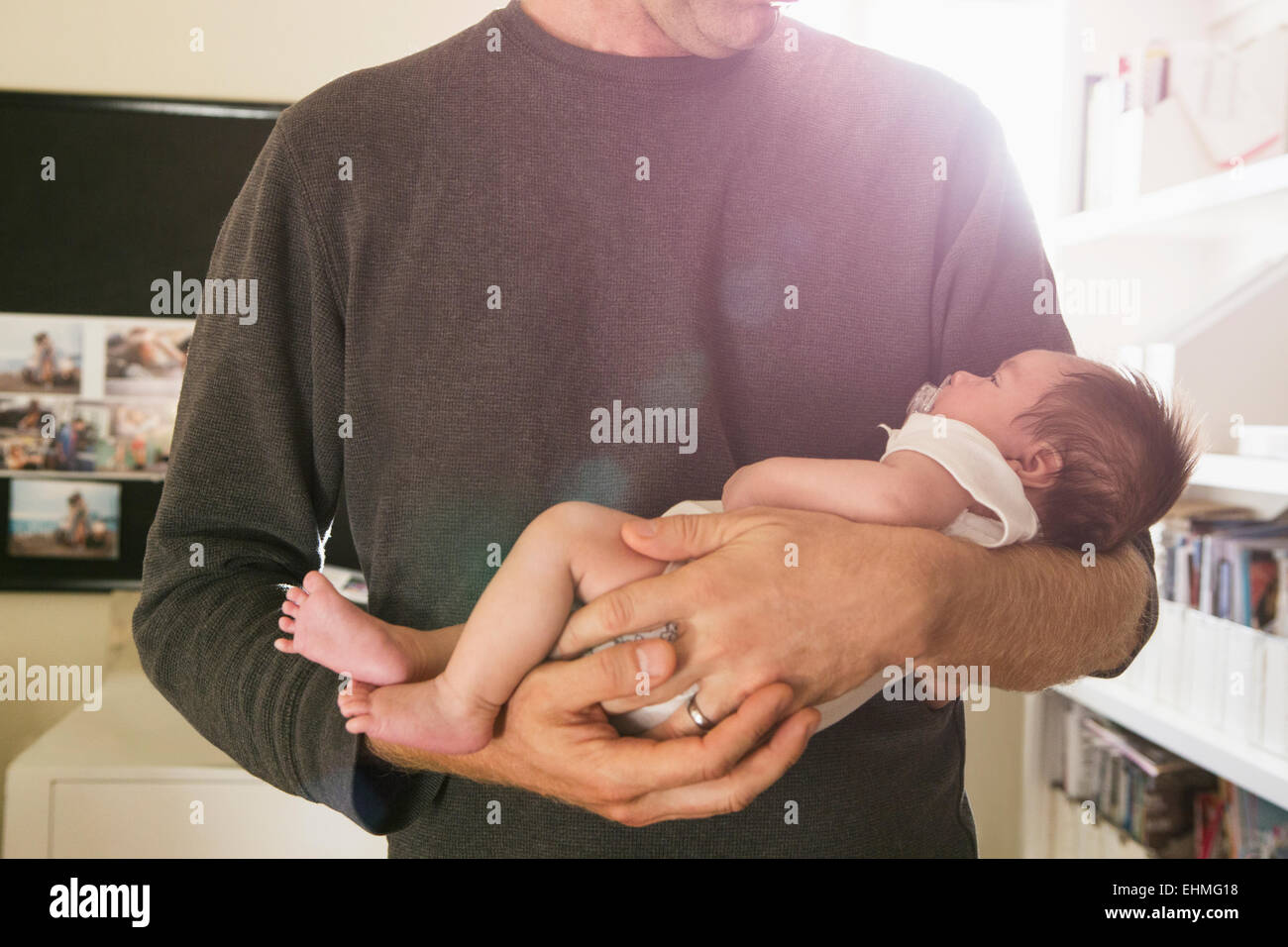 Padre holding neonato in camera da letto Foto Stock