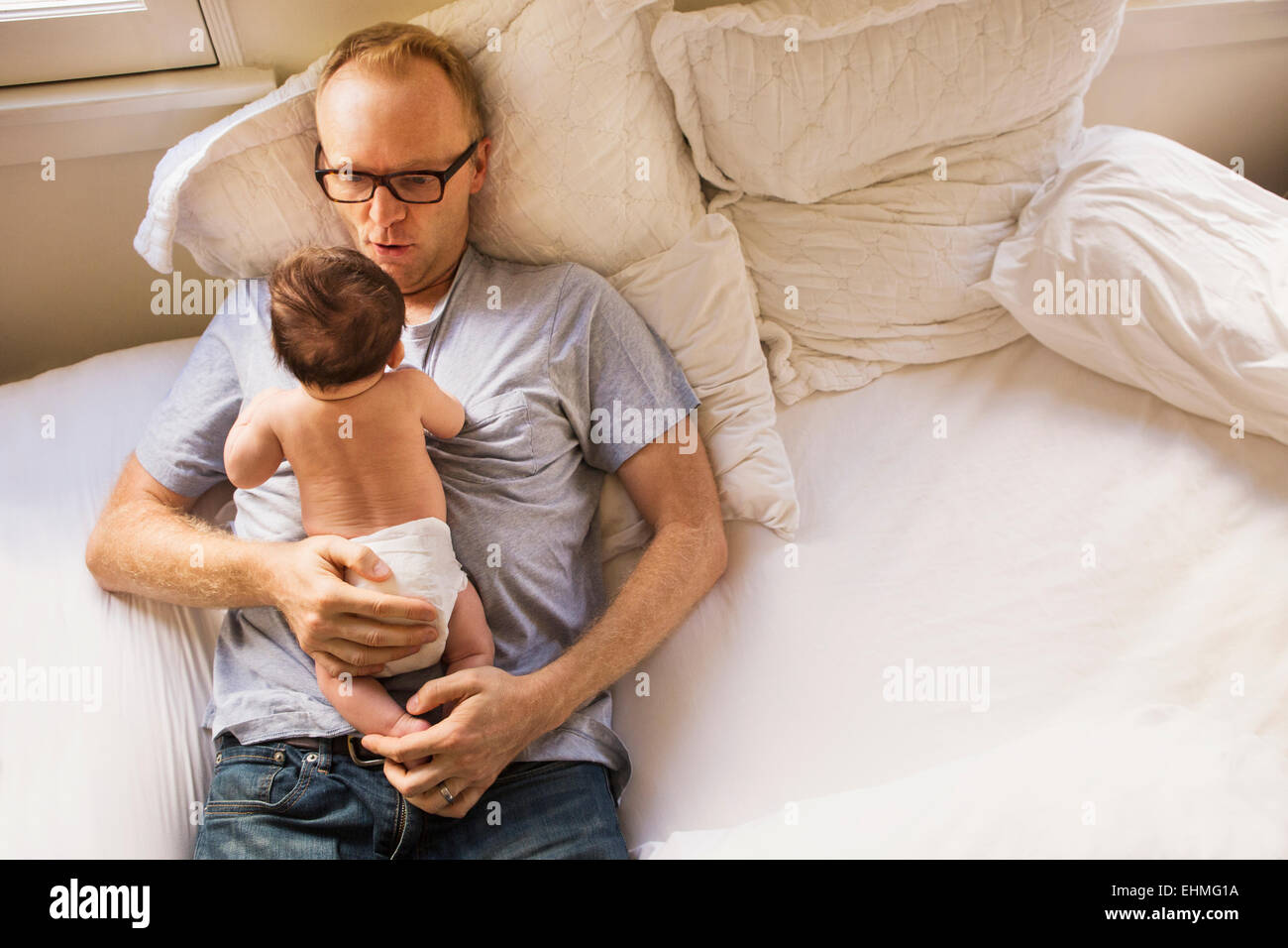 Padre giocando con il bambino sul letto Foto Stock