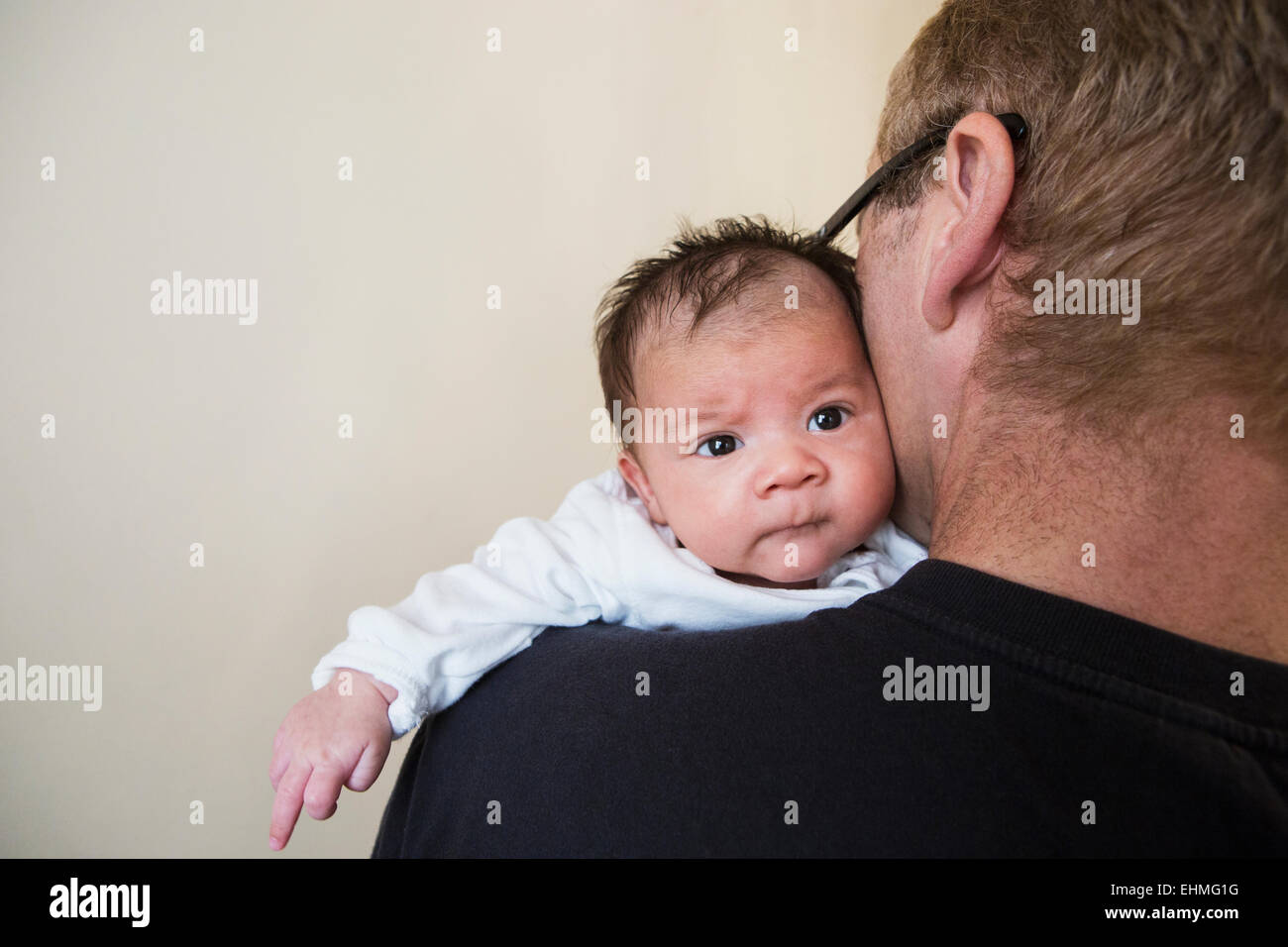 Close up di padre holding razza mista baby Foto Stock