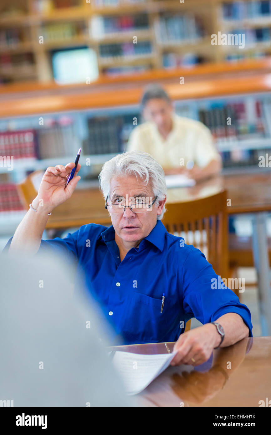 Studente adulto alzando la mano in classe Foto Stock
