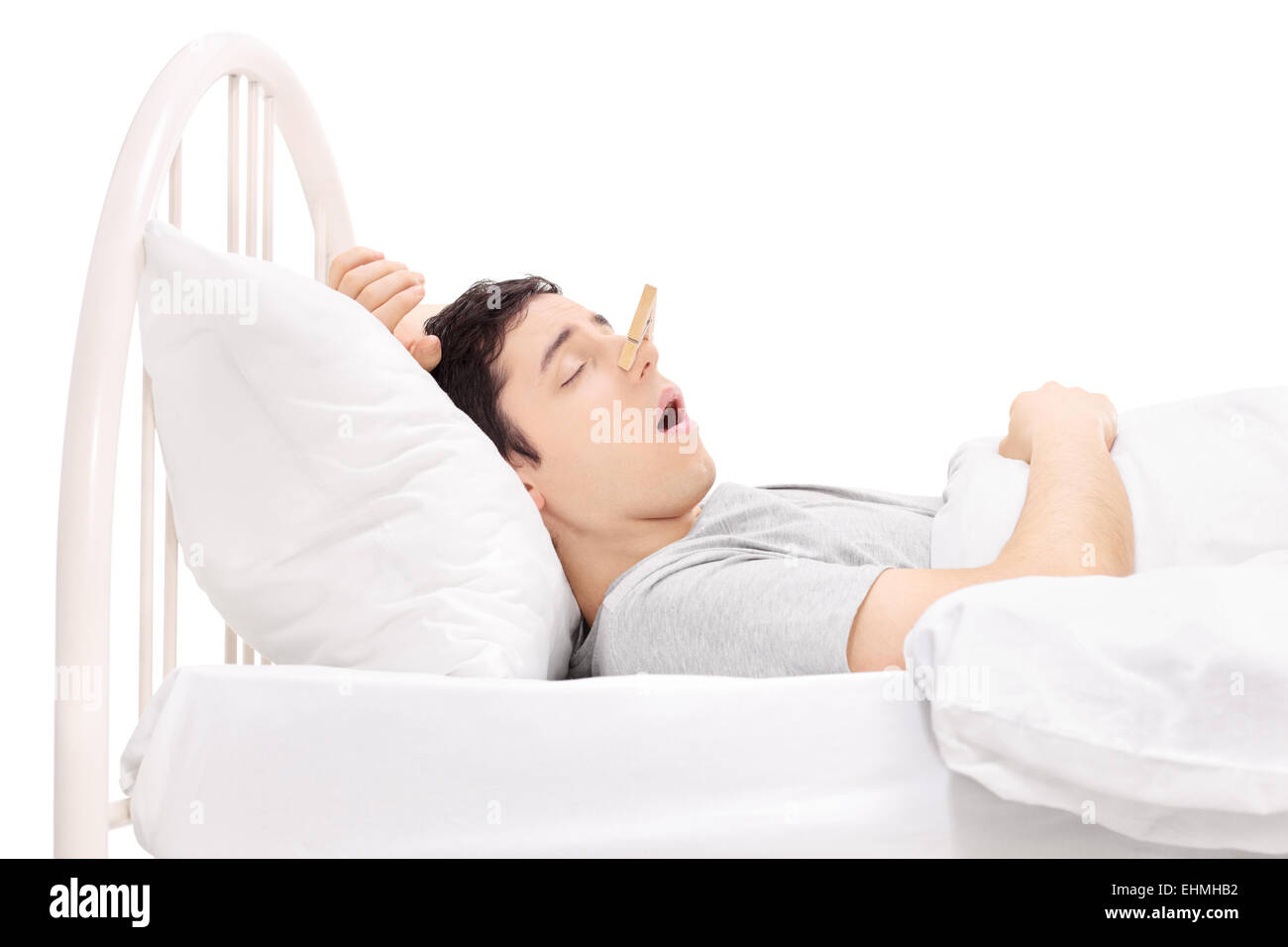 Uomo dorme con un clothespin sul suo naso isolati su sfondo bianco Foto Stock
