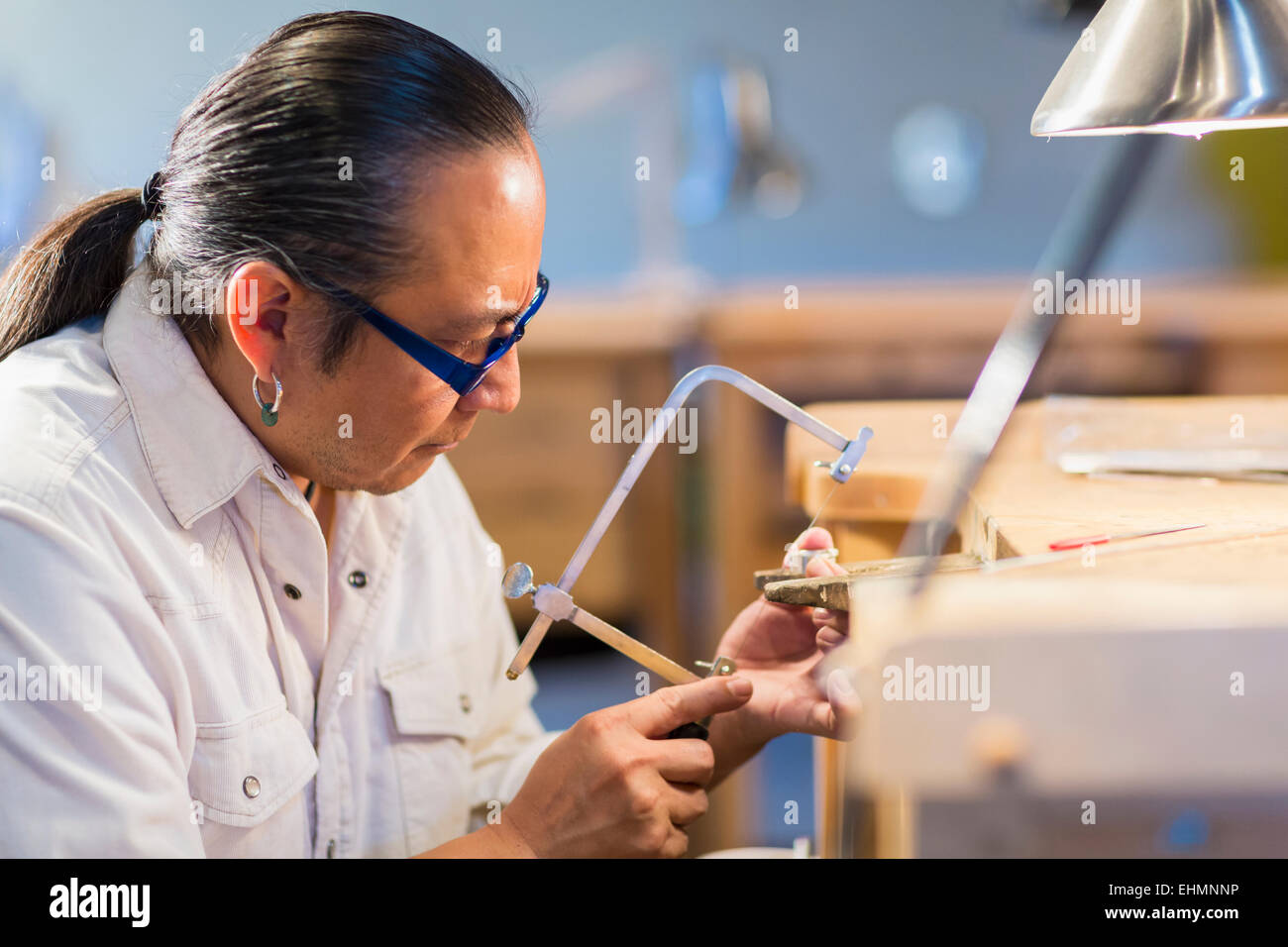 Native American gioielliere lavorando in studio Foto Stock