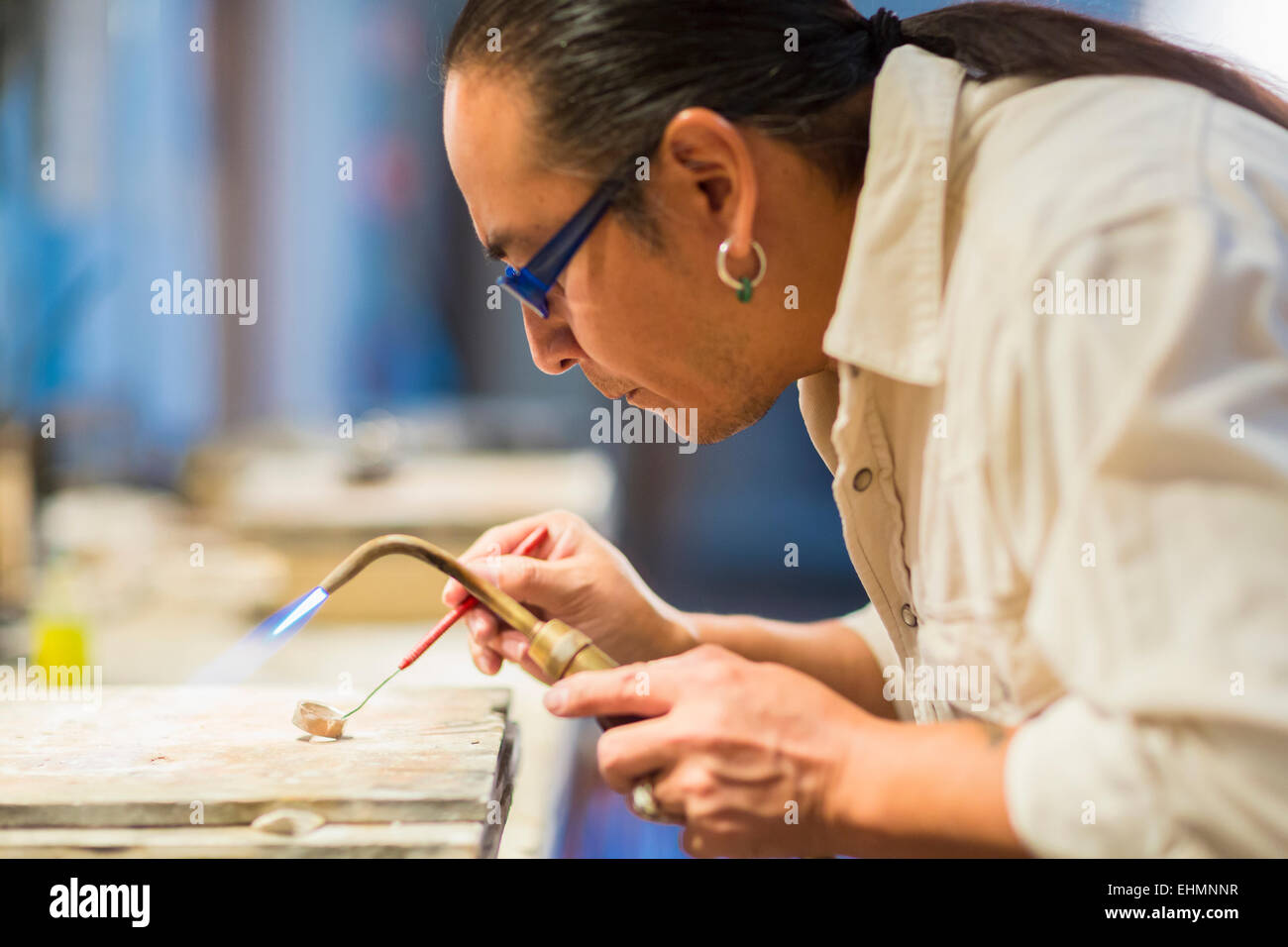 Close up dei Nativi Americani gioielliere con cannello in studio Foto Stock