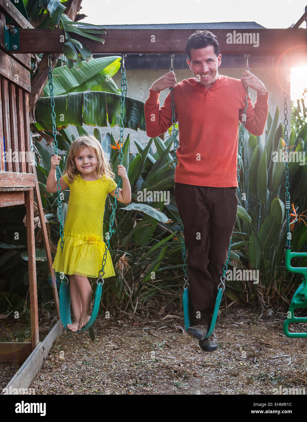 Caucasian padre e figlia in piedi su altalene Foto Stock